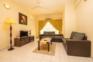 sala de estar con sofá y TV en Kijal Permai Apartment, en Kijal