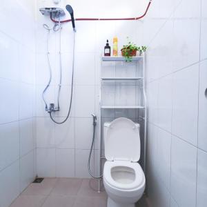 a white bathroom with a shower with a toilet at Snooze Ijen in Banyuwangi
