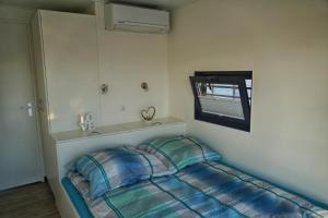 um pequeno quarto com uma cama e uma janela em Floatinghouse Bacchus em Braunsbedra