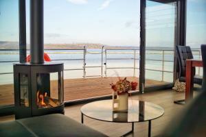 a living room with a fireplace and a view of the water at Floatinghouse Bacchus in Braunsbedra