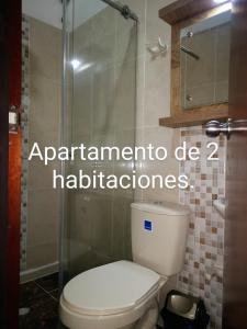 a bathroom with a toilet and a glass shower at Cómodos y acogedores Apartaestudios - Manizales in Manizales