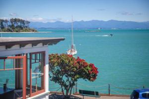 a house with a view of the water with a boat at The Pilot House - Nelson - 1862 in Nelson