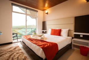 a bedroom with a large bed with a large window at Moon Plains Luxury Apartments in Nuwara Eliya