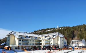 a large building on a ski slope in the snow at Enjoy Ferienwohnung Feldberg Grafenmatt in Feldberg