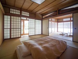 ein Schlafzimmer mit einem großen Bett in einem Zimmer mit Fenstern in der Unterkunft Ryokan Genhouin in Kyoto