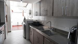 a kitchen with a sink and a dishwasher at Casa La Palma Habitación Cielo in Medellín