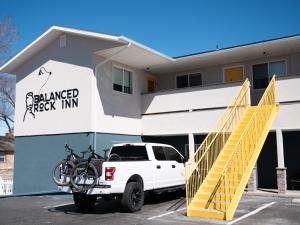 a white truck parked in front of a building with a bike on it at Balanced Rock Inn in Fruita