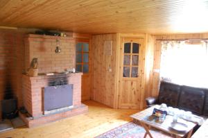 a living room with a brick fireplace and a table at Aratsaare Holiday home in Kõpu