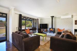 a living room with two couches and a fireplace at Aloha - Short Drive to Berry & The Beach - Fireplace and Firepit in Shoalhaven Heads