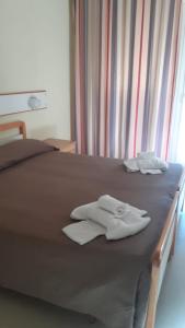 1 cama con 2 toallas plegables encima en Hotel Laurin, en Lido di Camaiore