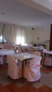 une chambre avec des tables et des chaises et une chambre avec des fenêtres dans l'établissement Hotel Laurin, à Lido di Camaiore