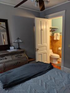 a bedroom with a bed and a dresser and a bathroom at The Avanti Houses in South Bend