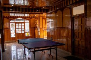 a ping pong table in a room with wooden walls at Hotel KALPA in Kalpa