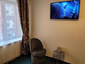 um quarto com uma cadeira e uma televisão na parede em Apartamentai Vyta em Klaipėda