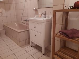 een badkamer met een wastafel, een bad en een wastafel bij Altes Winzerhaus in Traben-Trarbach
