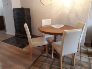 een eettafel met witte stoelen en een kast bij Altes Winzerhaus in Traben-Trarbach