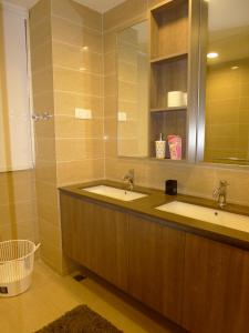 Baño con 2 lavabos y espejo en By The Sea Suite,Batu Ferringhi, en Batu Ferringhi