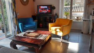 a living room with a couch and a chair and a table at Appartement Maison Croisette in Sainte-Maxime