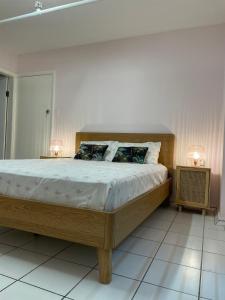 a bedroom with a large bed with two lamps on it at The Espy Hostel in Cairns +25 photos