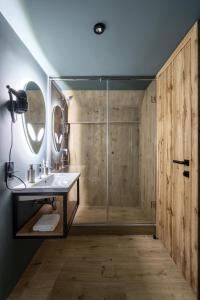 a bathroom with a shower with a sink and a mirror at Baza Smart Hotel in Bukovel