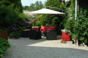 a patio with chairs and an umbrella in a garden at Cornelia Kolpak-Krieger in Pegnitz