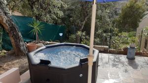 a hot tub with an umbrella in a backyard at Appartement Maison Croisette in Sainte-Maxime
