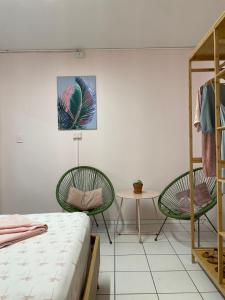 a bedroom with two chairs and a table and a bed at The Espy Hostel in Cairns