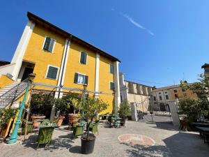 a yellow building with tables and chairs in a courtyard at Camere Formigola in Corticelle Pieve