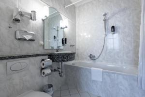 La salle de bains est pourvue d'une baignoire, de toilettes et d'un lavabo. dans l'établissement Trip Inn Klee am Park Wiesbaden, à Wiesbaden