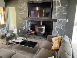 a living room with a couch and a fireplace at The Retreat Tamborine Mountain in Mount Tamborine