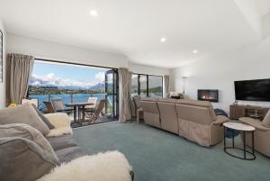 a living room with a couch and a tv and a table at Exciting Queenstown in Queenstown