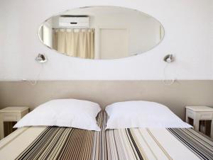 Un ou plusieurs lits dans un hébergement de l'établissement Hotel L'Orangeraie