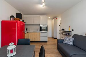 a living room with a couch and a red refrigerator at Cristallo apartment - ristrutturato nuovo centro Aprica in Aprica +15 photos