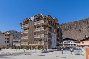 a large apartment building in front of a mountain at Cristallo apartment - ristrutturato nuovo centro Aprica in Aprica