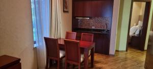 a dining room table with chairs and a kitchen at Dreamland Oasis Chakvi in Chakvi