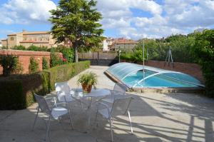 a table and chairs next to a swimming pool at Huertas de la Fuente in Cella