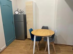 a table and chairs in a room with a refrigerator at Gite du Port in Dieppe