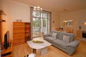 ein Wohnzimmer mit Couch und Fernseher in der Unterkunft Villa Seestern, App. 3 in Bansin