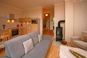 ein Wohnzimmer mit Couch und Ofen in der Unterkunft Villa Seestern, App. 3 in Bansin