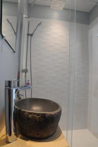 La salle de bains est pourvue d'une douche avec un grand lavabo en pierre. dans l'établissement L'équipage - Hyper centre, charme et calme à deux pas de la mer, à Cabourg