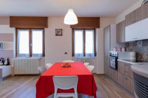 cocina con mesa y mantel rojo en Europa Master Guest apartment, en Aprica