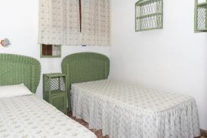 a room with two green beds and two windows at Arensol Esc-A, 13º-51 in Cullera +16 photos