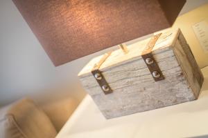 eine Holzkiste auf einem Tisch neben einer Lampe in der Unterkunft Ferienwohnung Tau Hus Keitum Sylt in Keitum