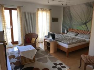 - une chambre avec un lit, un canapé et des chaises dans l'établissement Ferienapartments im Hintergässel, à Sankt Martin