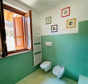 スルツァーノにあるXIO HOMEの緑のタイル張りのバスルーム(トイレ、シンク付)