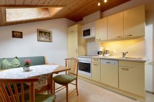 Haus Traudl في مايرهوفن: مطبخ وغرفة طعام مع طاولة وكراسي