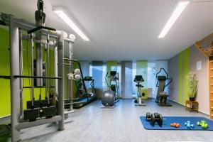 ein Fitnessstudio mit Laufbändern und Trainingsgeräten in einem Raum in der Unterkunft Familien Apartmenthotel Panoramic in Bad Lauterberg