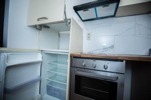 uma cozinha com um fogão e um frigorífico aberto em Agréable chambre sur liège avc parking et wifi gratuit em Liège
