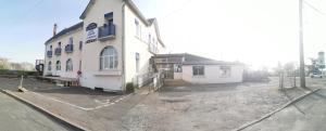 a white building with a sign on the side of it at le relais de l aiguillon in Châtellerault
