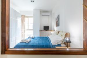 a bedroom with a blue bed with a window at Teatro Politeama and Teatro Massimo Cozy Apartment in Palermo